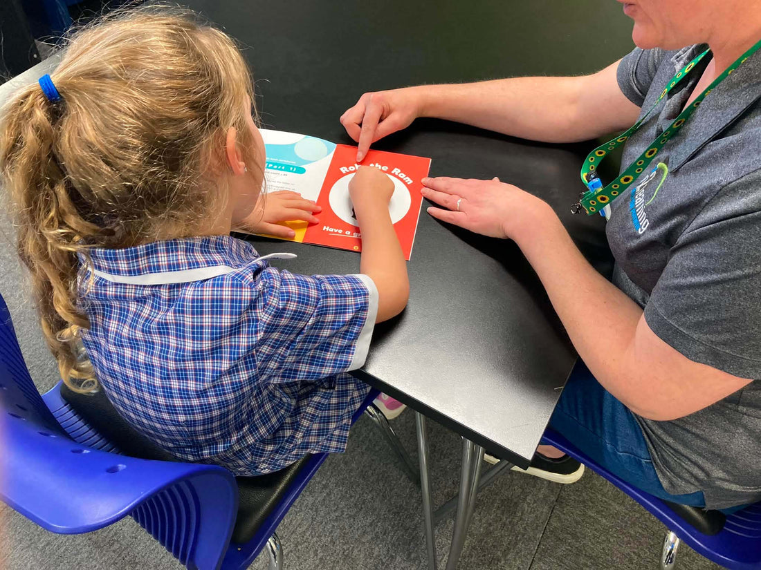 A tutor supporting a child with reading